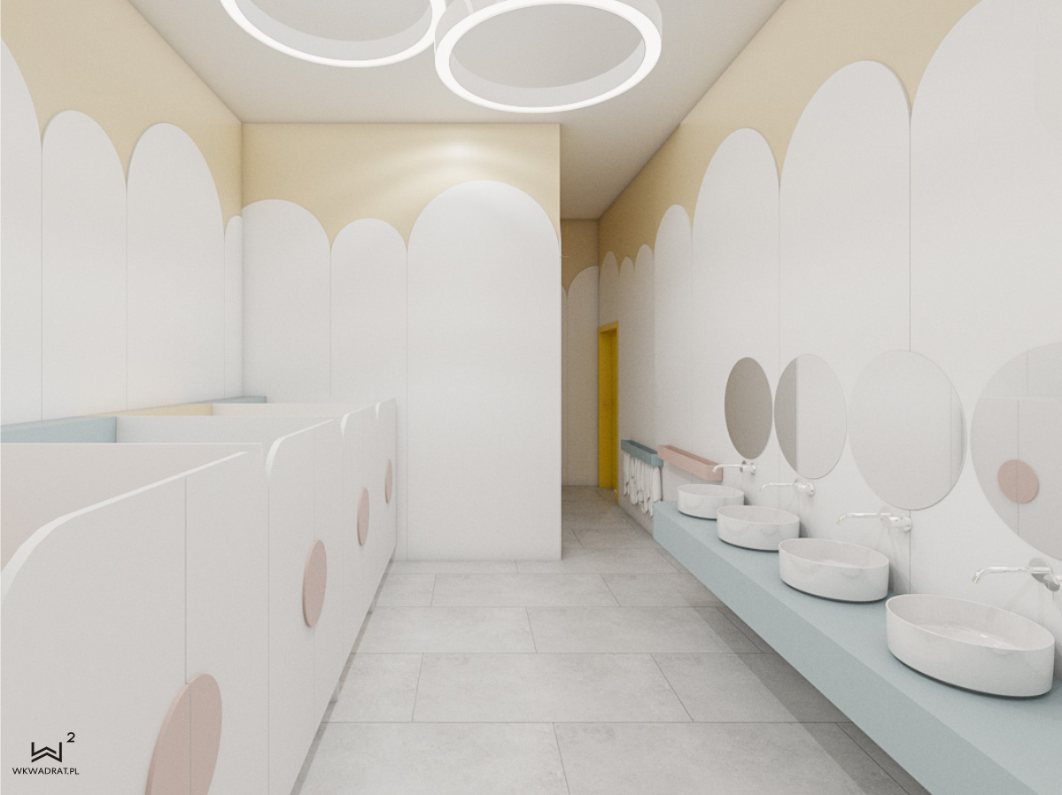 Projekt łazienki dla dzieci wykonany przez Pracownię Projektowania Wnetrz Wkwadrat, dgdzie możemy zobaczyć szereg umywalek montowanych na niskiej wysokości.
